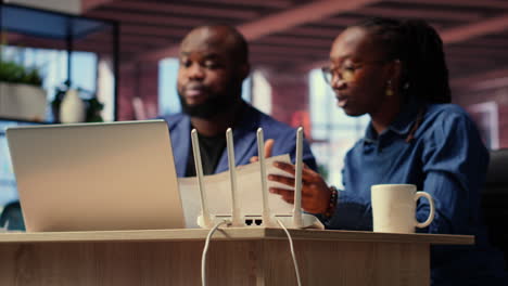 black irritated man and woman rebooting their wireless router