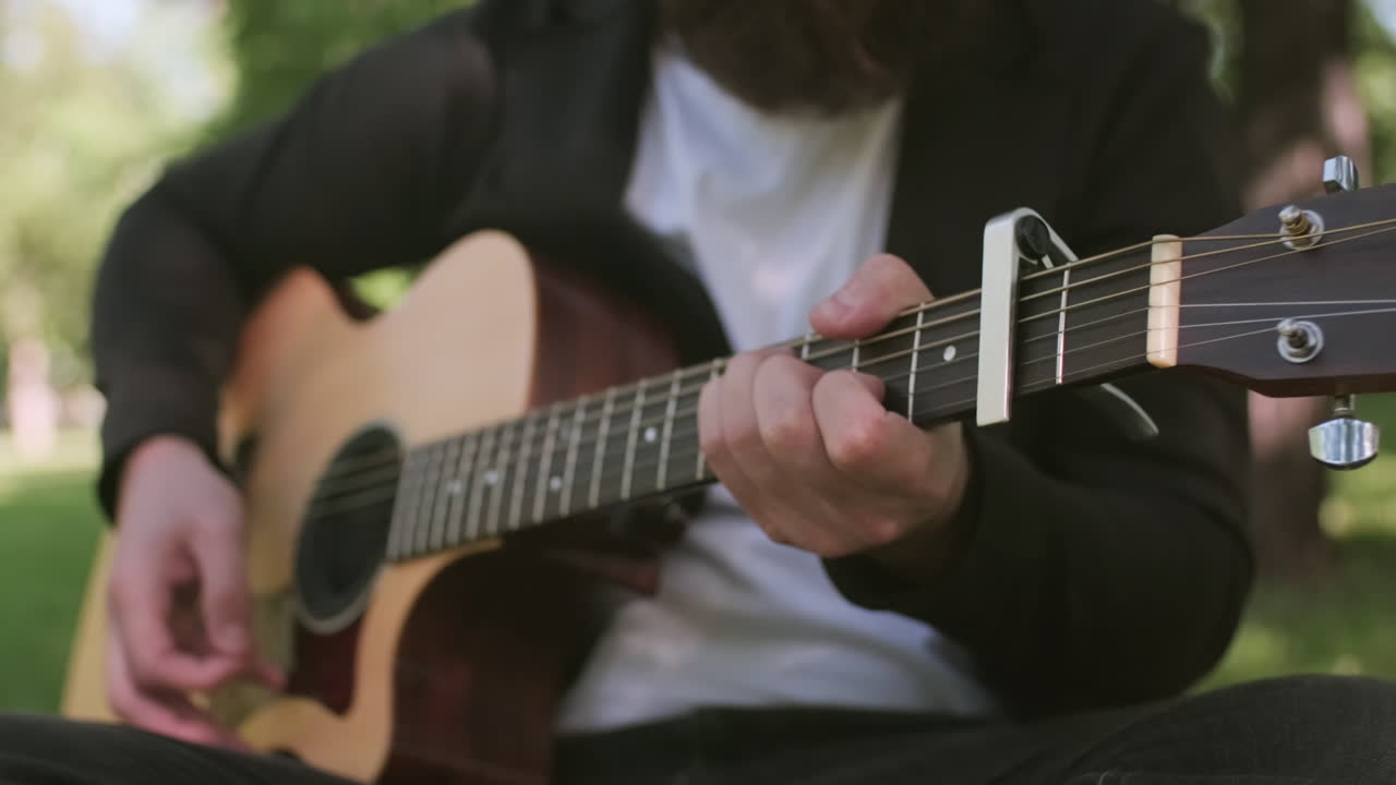 Unrecognizable Man Playing Acoustic Guitar Outside