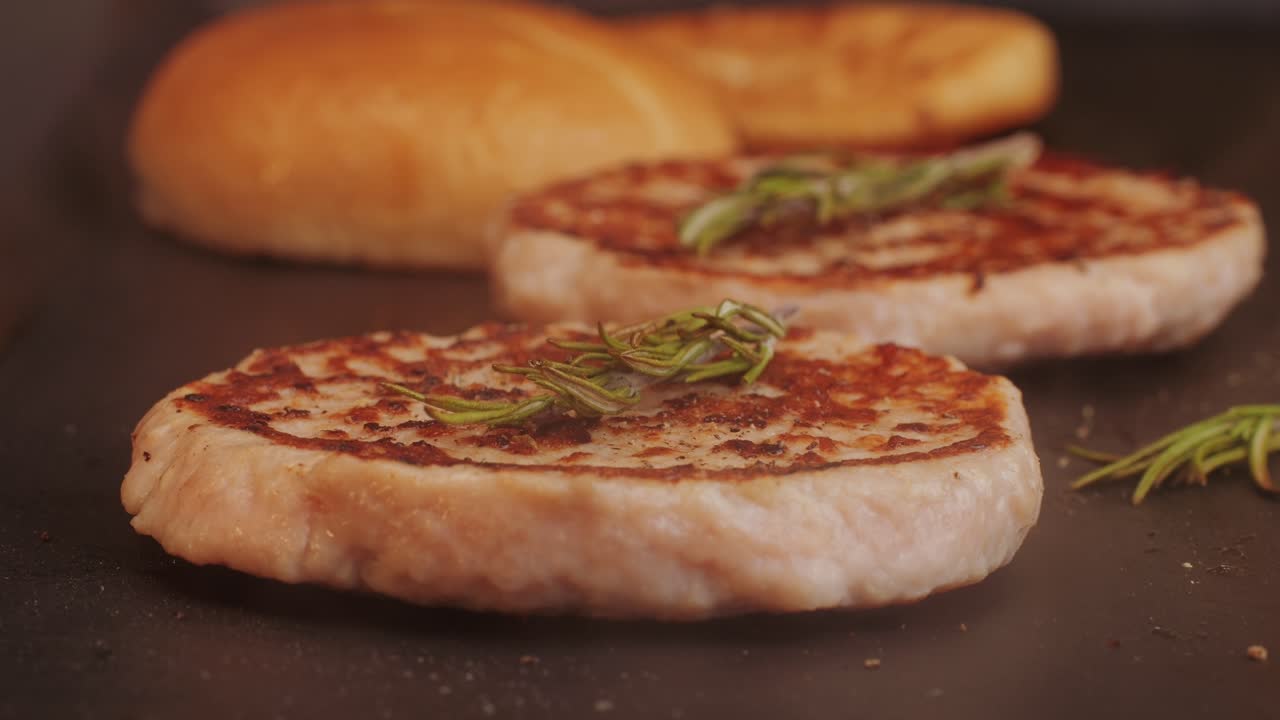 Cooking American fat smash burger on grill close-up. Chiken or fish cutlet smashing by burger press. The chef in kitchen of the restaurant making cutlets for burgers - smash burger beefsteak. Fast and street food concept. High quality 4k footage