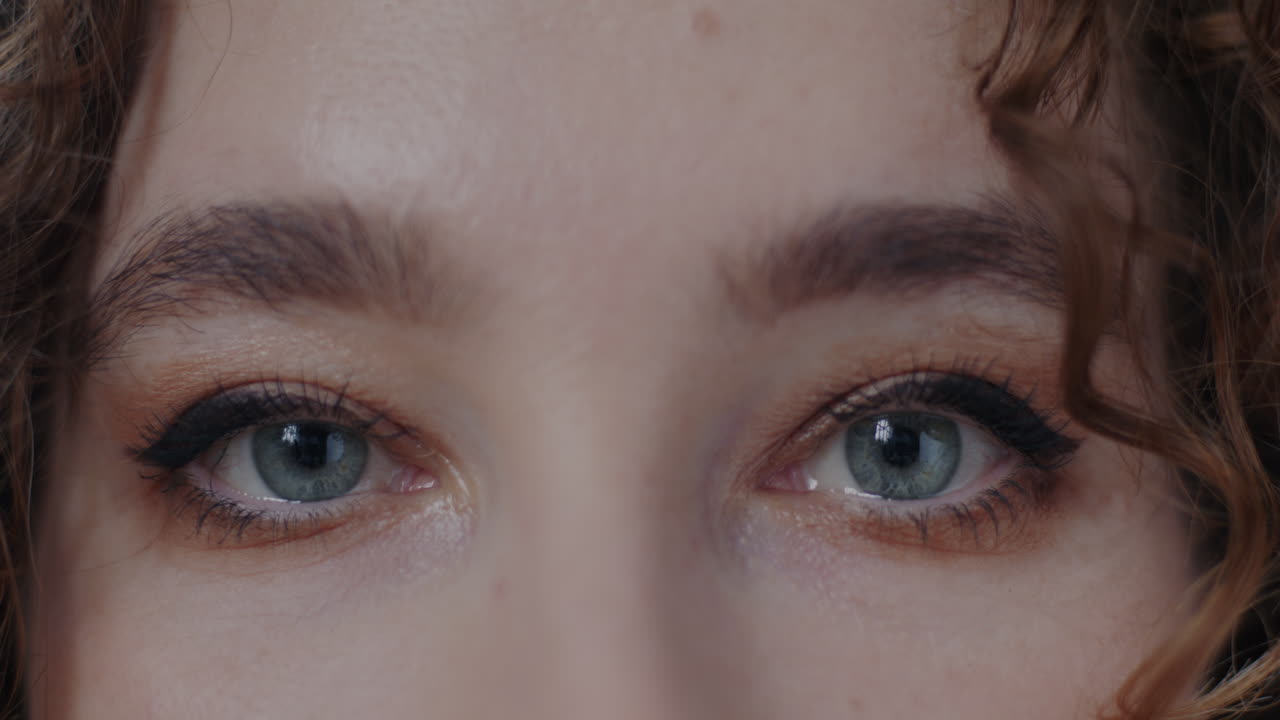 Close-up of a woman's face with makeup and curly hair