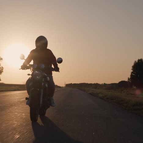 silhouette of a motorcycle biker riding on the highway