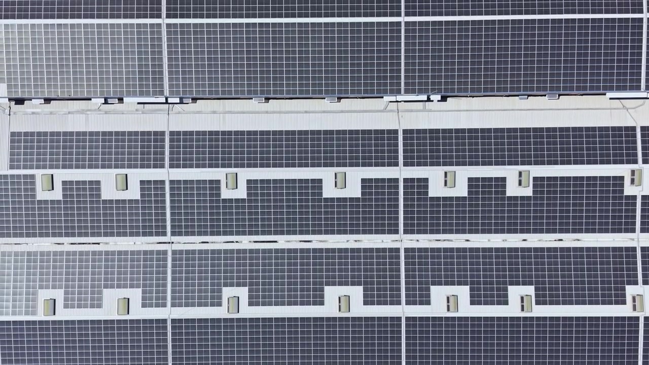 Pannelli solari coprono il tetto di un grande edificio in una posizione soleggiata, mostrando l'uso di energia rinnovabile nell'architettura moderna.
