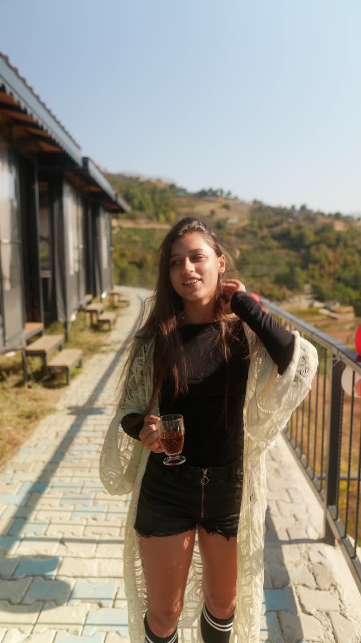 una mujer disfrutando de la vista con una bebida.