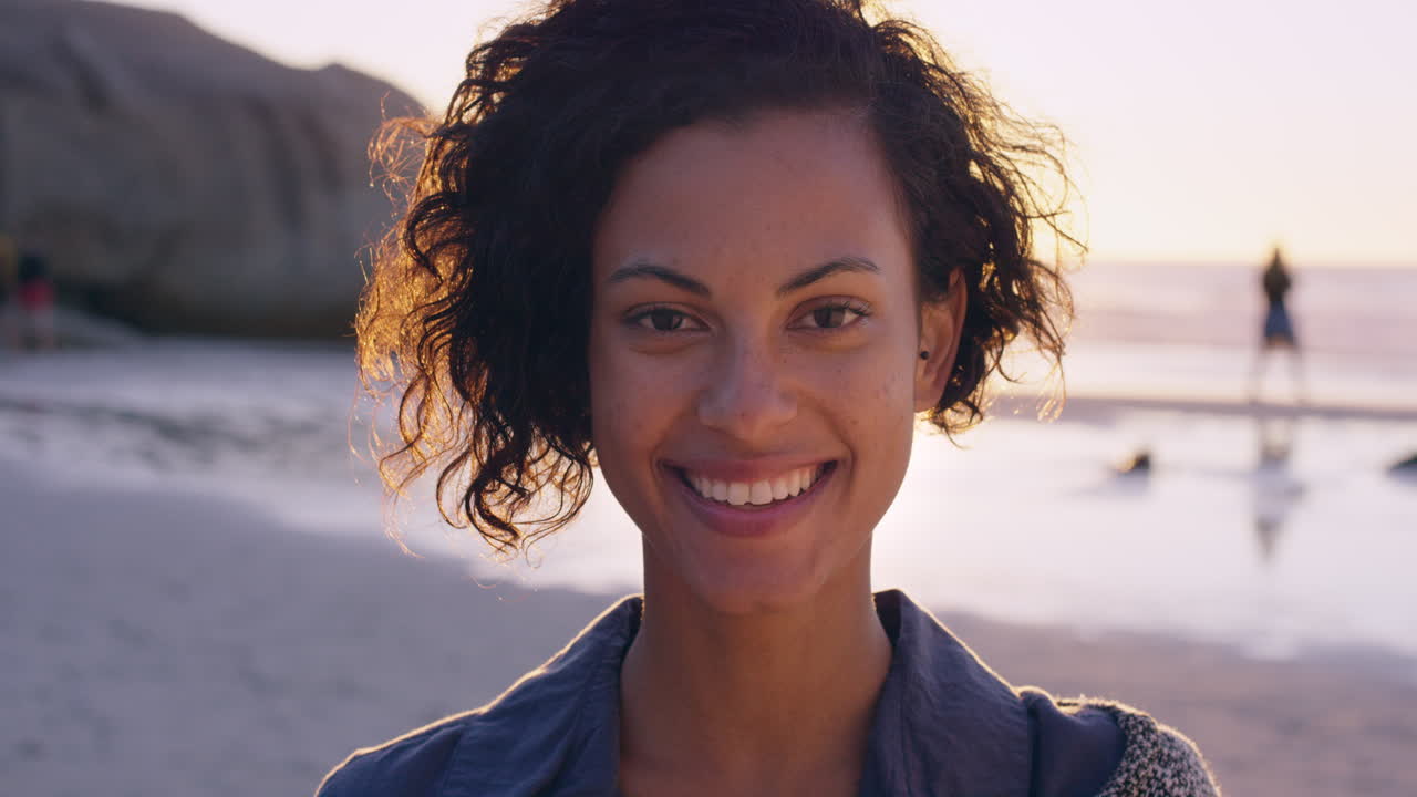 retrato de una hermosa chica sonriendo en la playa al atardecer en cámara lenta