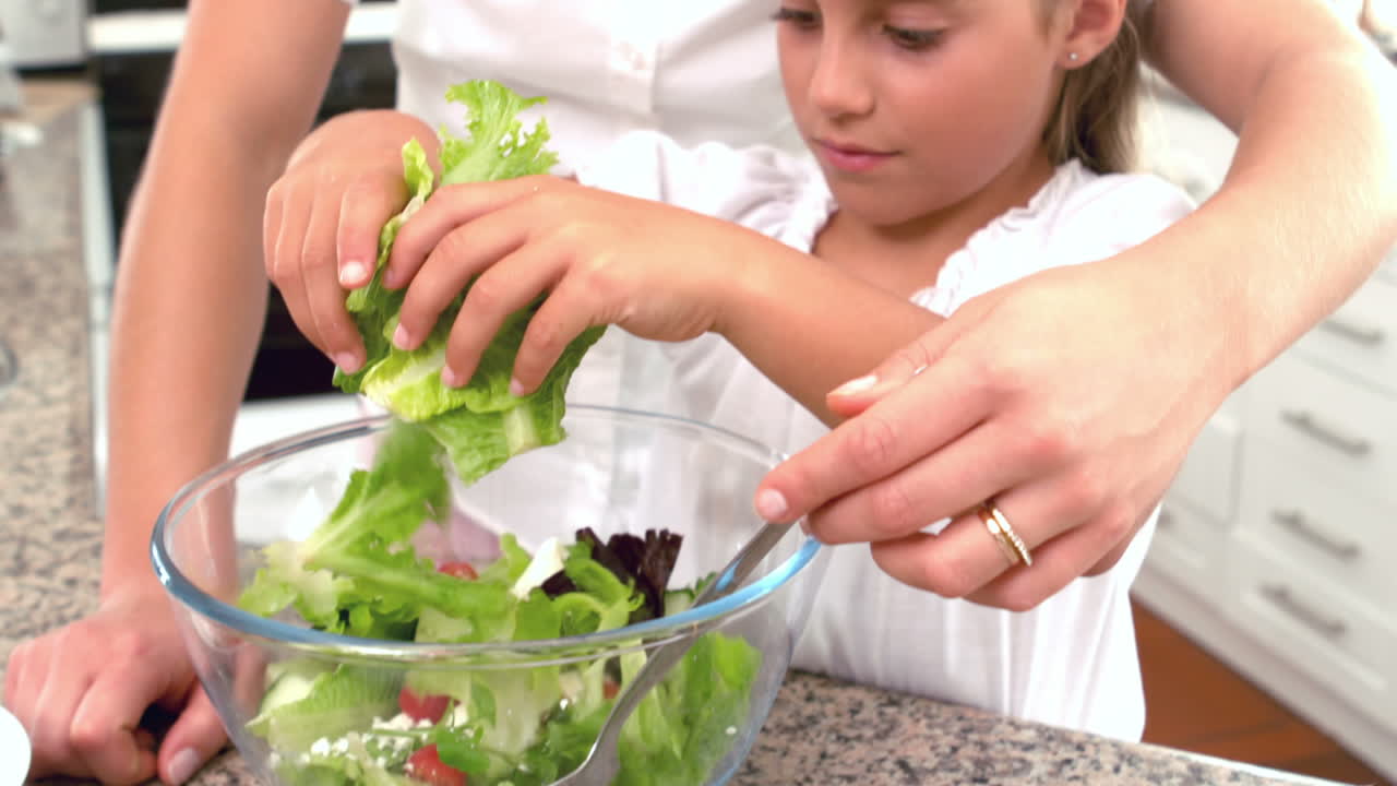 madre e hija preparando ensalada juntos