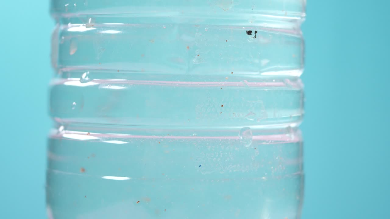 primer plano de una botella de agua de plástico con microplásticos