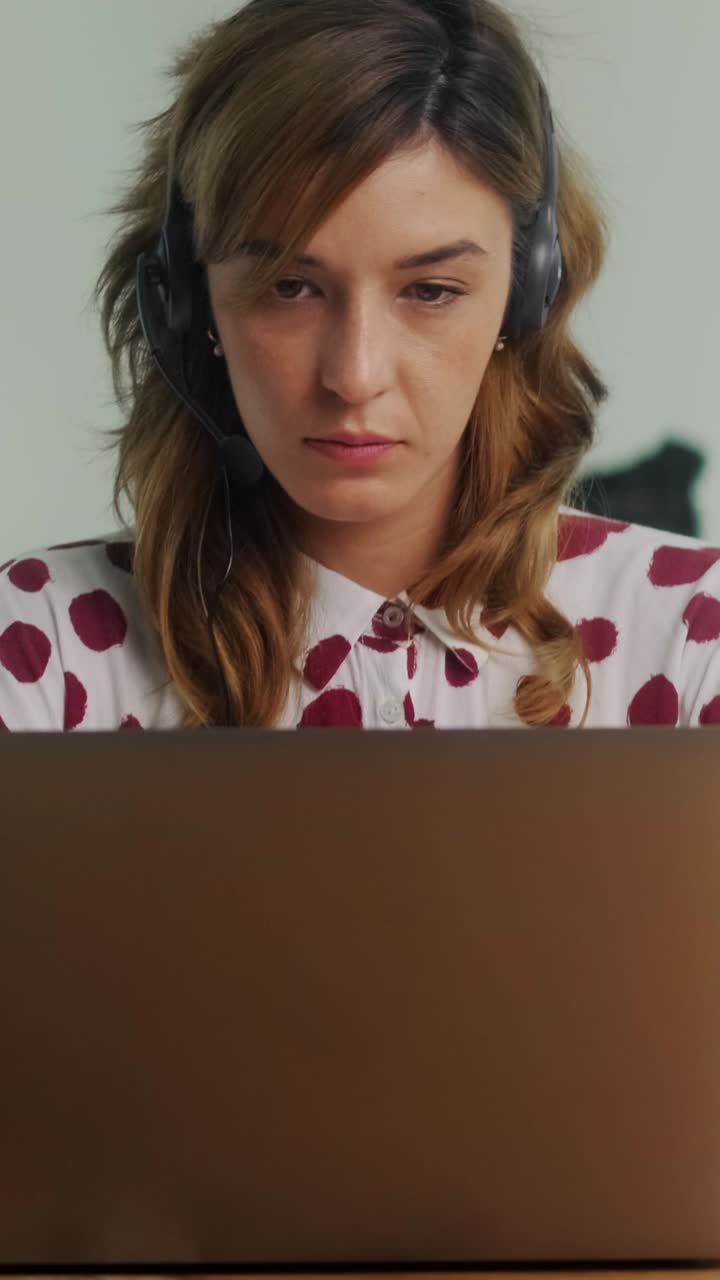 Woman engages in online meeting while wearing headset in modern office