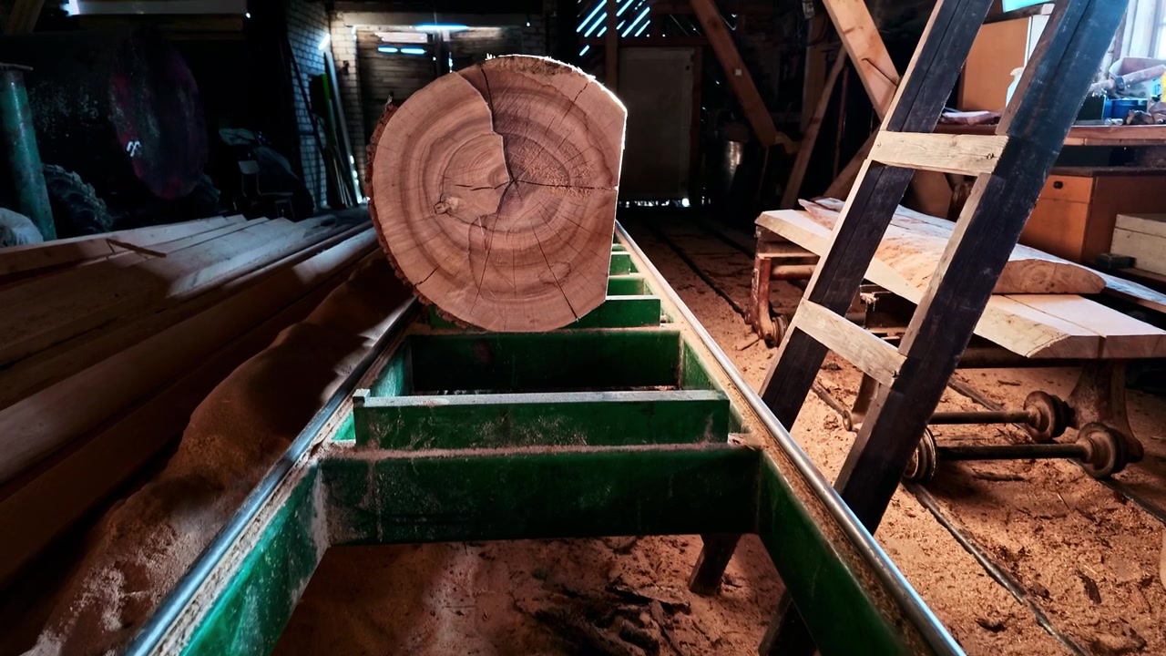 Old Band Saw in sawmill with log on rails in slow motion closeup