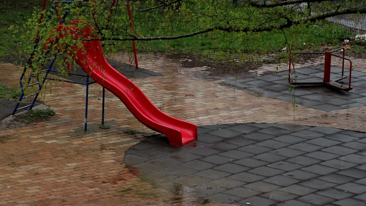 nieve que cae en el patio de recreo en el parque de la ciudad en primavera en ventisca en el día