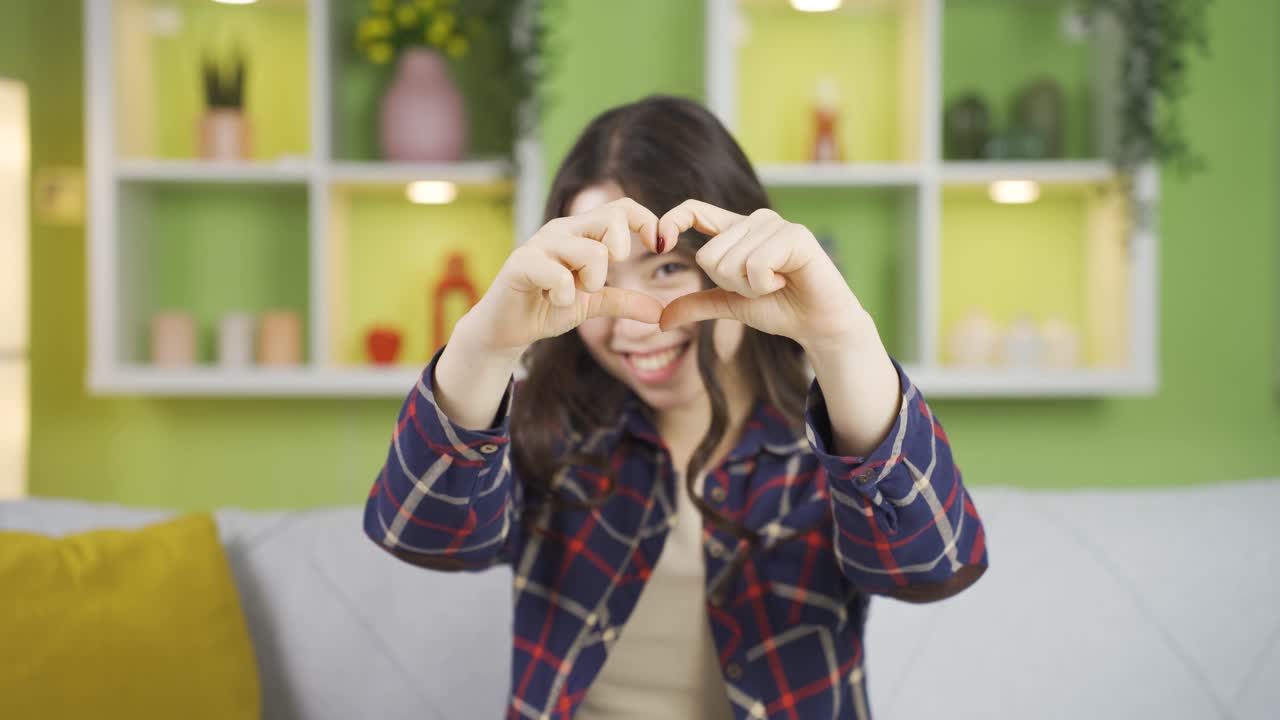 아름다운 아시아 젊은 여성이 카메라에 심장을 만들고 있습니다.