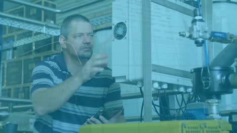 animation of financial data over caucasian male factory worker with tablet