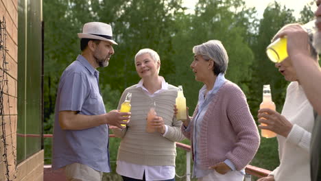 group of senior people dancing, talking and having a drink