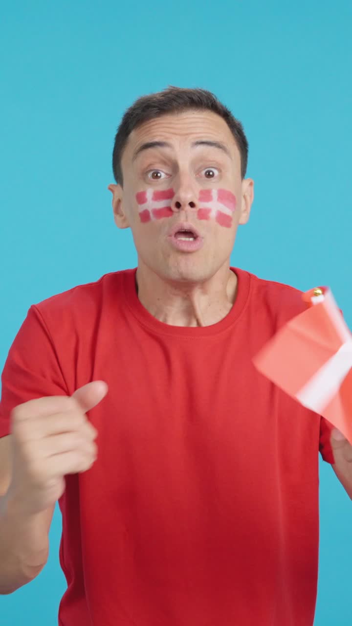 Man cheering for Denmark screaming and waving a national flag
