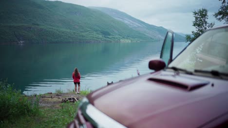 woman standing near lake during camping in sørfold, norway - wide