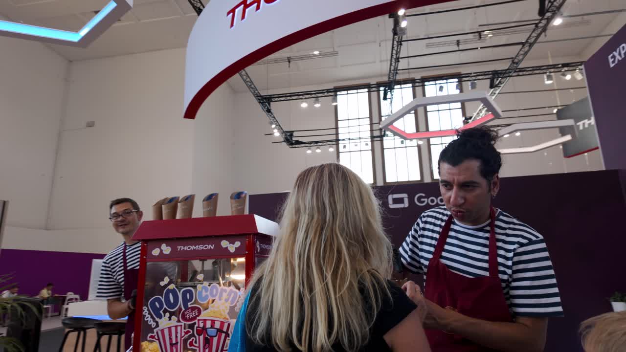 People Buying Popcorn At IFA Exhibition Booth In Berlin, Germany, handheld shot
