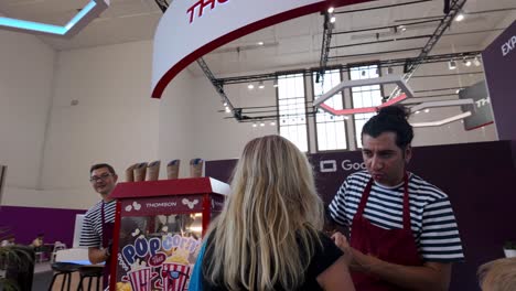people buying popcorn at ifa exhibition booth in berlin, germany, handheld shot