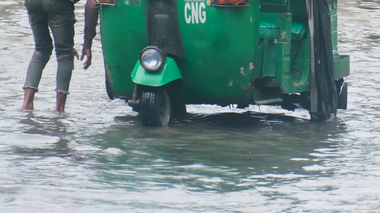 Man pulling rickshaw through floodwater