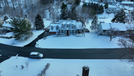 Blue-Cape-Cod-home-in-USA-covered-in-winter-snow