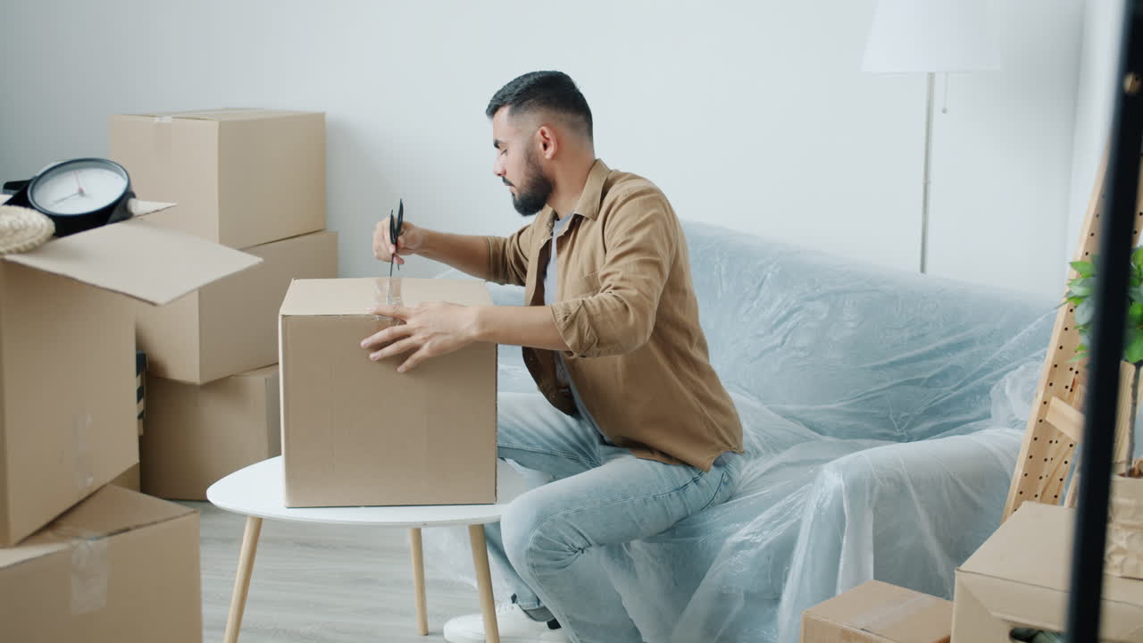 hombre desempaquetando cajas en un nuevo hogar