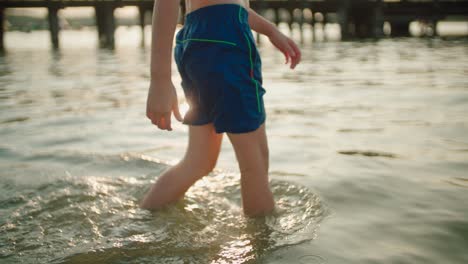 The-boy-enters-the-lake,-slow-motion