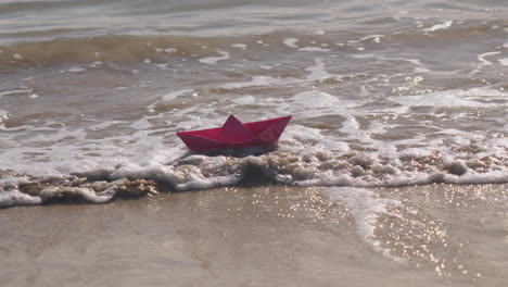 Origami-boat-floats-in-the-sea-and-gets-sunken-by-the-wave