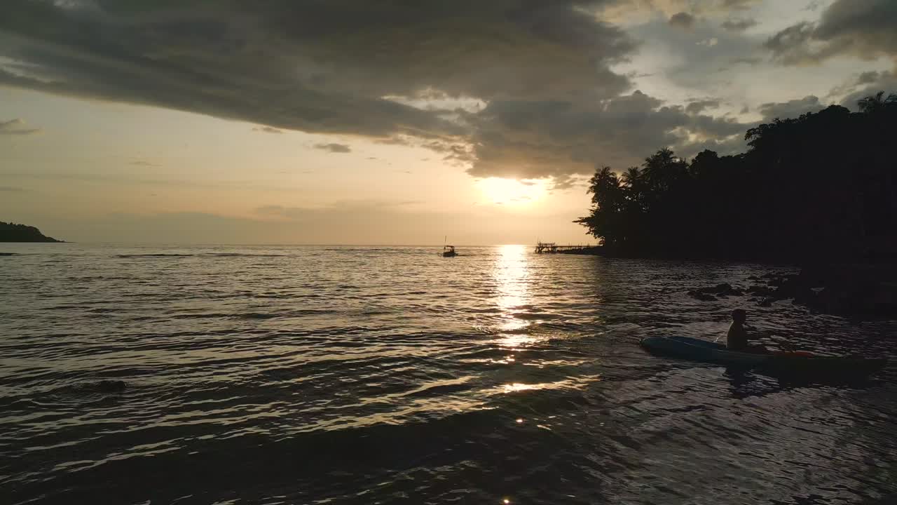 rayo de sol reflejado en canoa y barco de paletas de mar