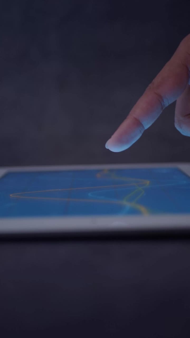 Main touchant l'écran d'une tablette numérique avec des données lumineuses.