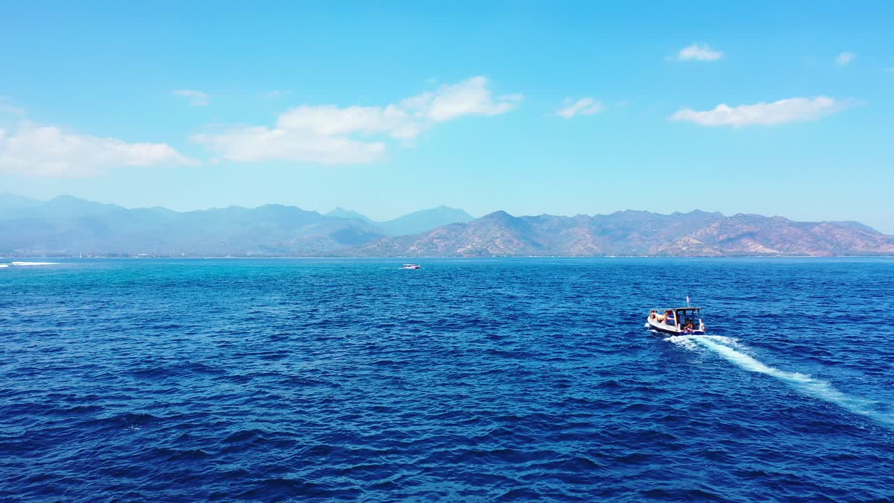 백그라운드에서 바다와 산의 아름다운 공중 파노라마, 롬복, 발리, 인도네시아에 접근하는 보트