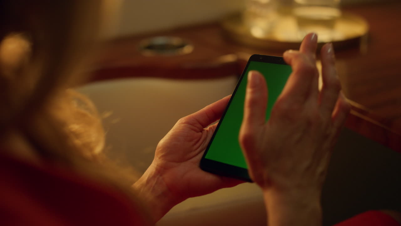 dama usando un teléfono inteligente verde en un primer plano de viaje corporativo. pantalla de maqueta de desplazamiento de la mano