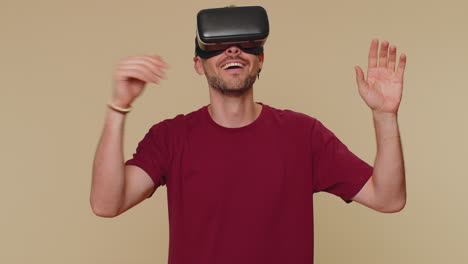 Young-man-using-headset-helmet-app-to-play-simulation-drawing-game-watching-virtual-reality-3D-video