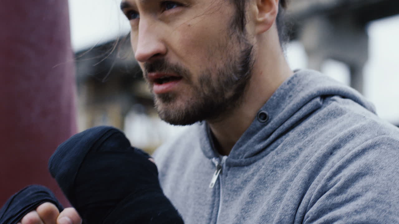 joven boxeador deportivo haciendo puñetazos en el aire durante el entrenamiento matutino en una mañana nublada