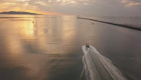 Aerial-follow-shot,-Pilot-boat-leaving-port-at-sunset