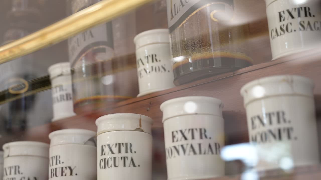 Scaffale con vecchie bottiglie bianche di medicinali in una farmacia