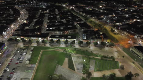 drone video capturing zipaquira parque la esperanza with sparkling streetlights, vibrant cityscape, and serene park areas at night. a captivating blend of urban and natural elements