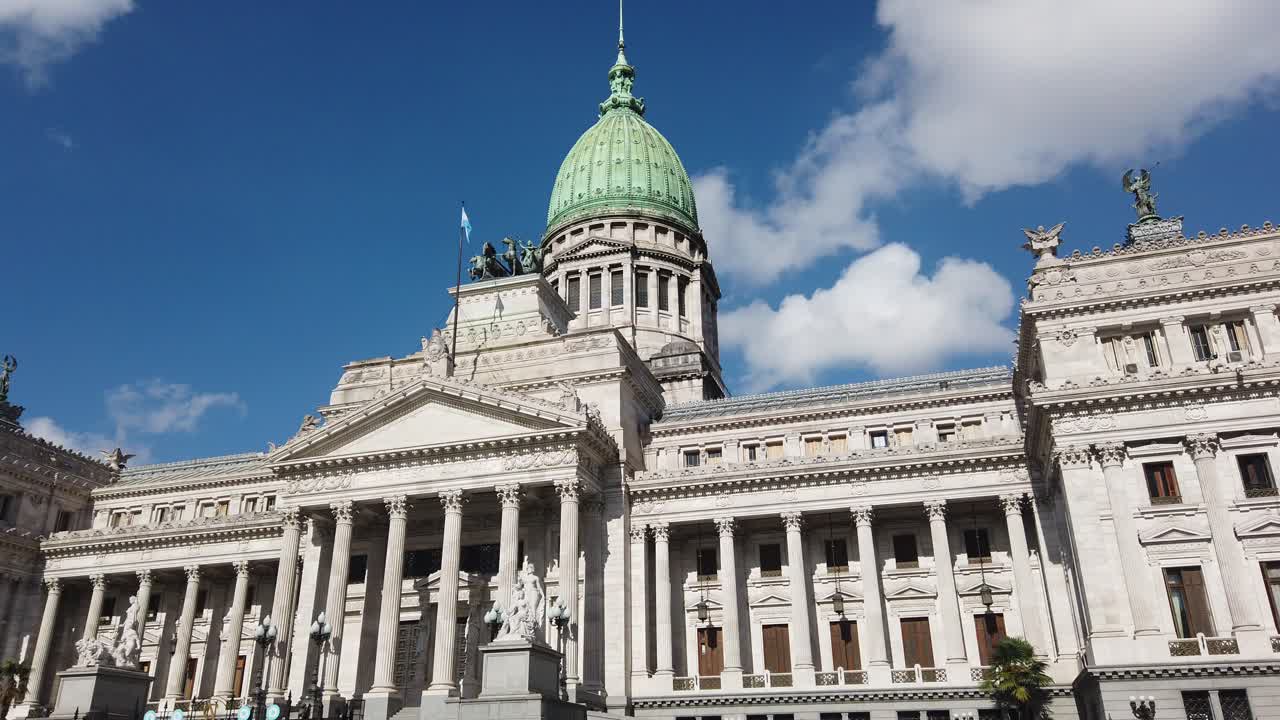 Vista frontal del Edificio del Congreso Nacional en Buenos Aires con bandera argentina ondeando y horizonte urbano