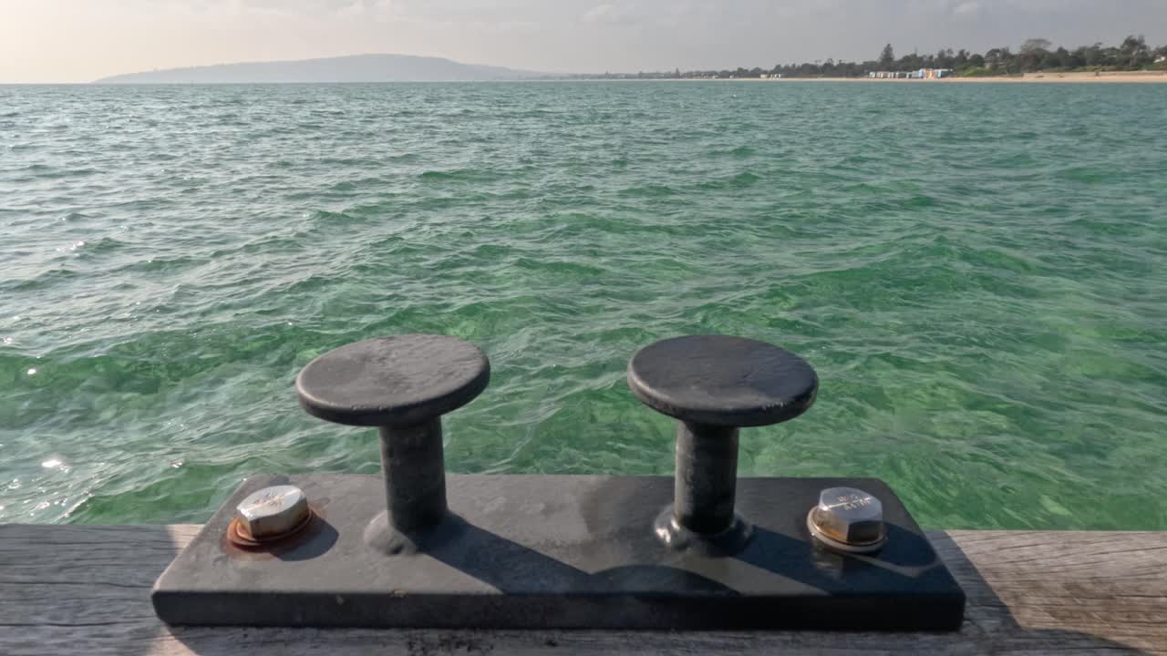 Mooring cleat on pier, calm bay waters
