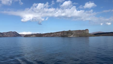 Schwenkansicht-Der-Insel-Nea-Kameni-Mit-Sanften-Wellen-In-Der-Caldera-Von-Santorin-Im-Mittelmeer