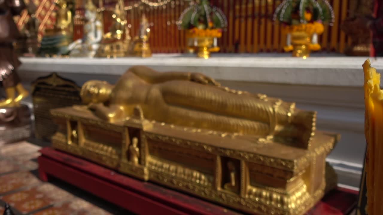 Primo piano da una candela accesa al Buddha d'oro disteso nel tempio