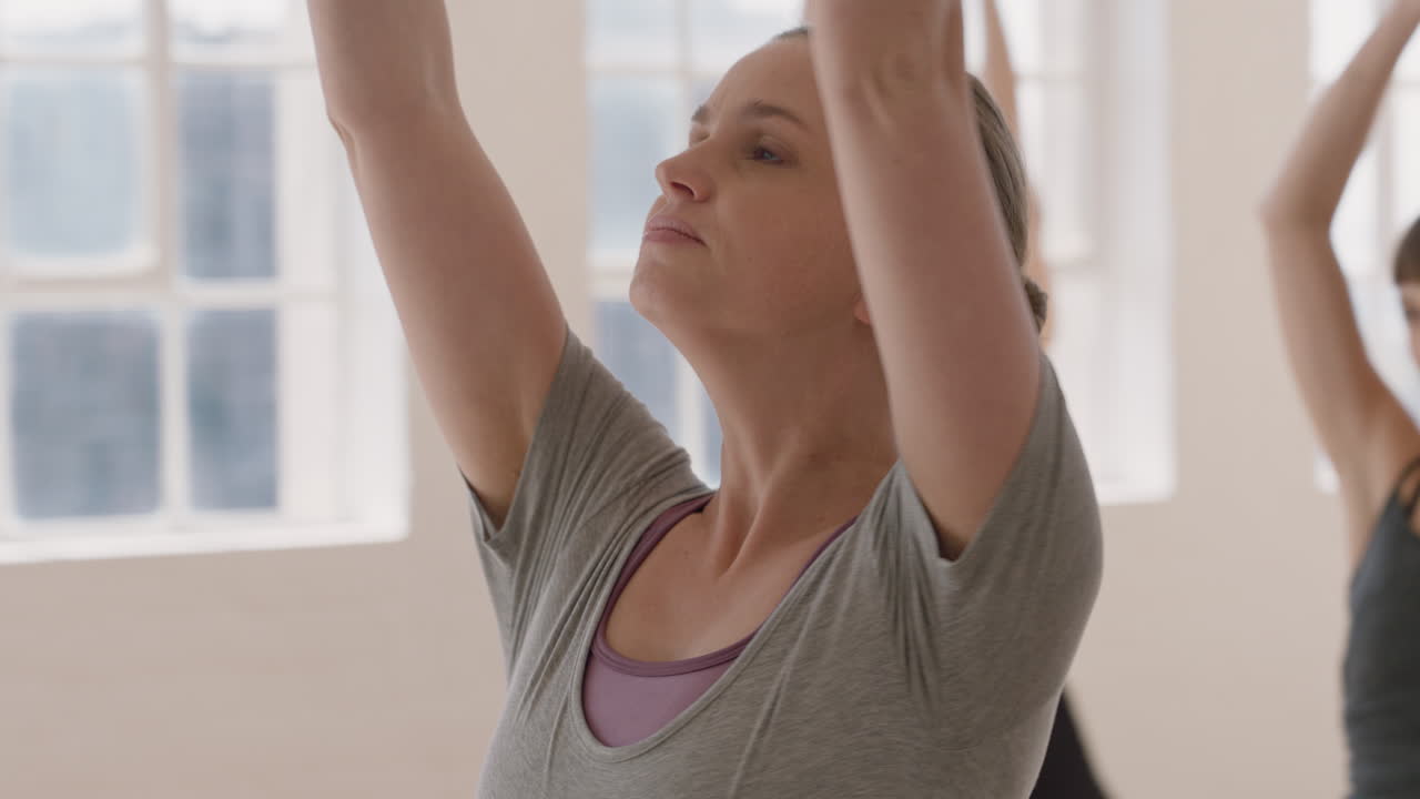 retrato joven mujer caucásica embarazada en clase de yoga practicando pose de guerrero disfrutando de un estilo de vida saludable haciendo ejercicio en grupo en el gimnasio