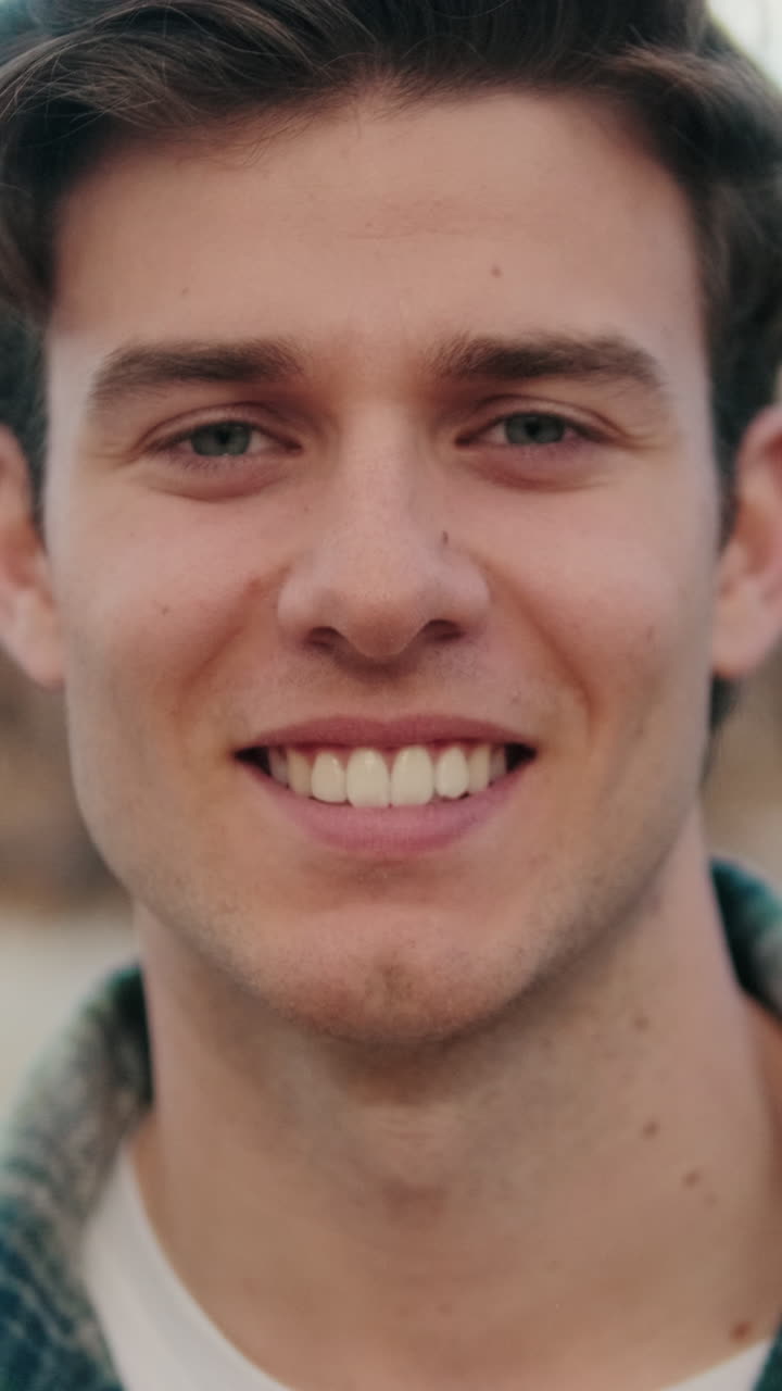 Close-up of young smiling man looking at camera on old city background