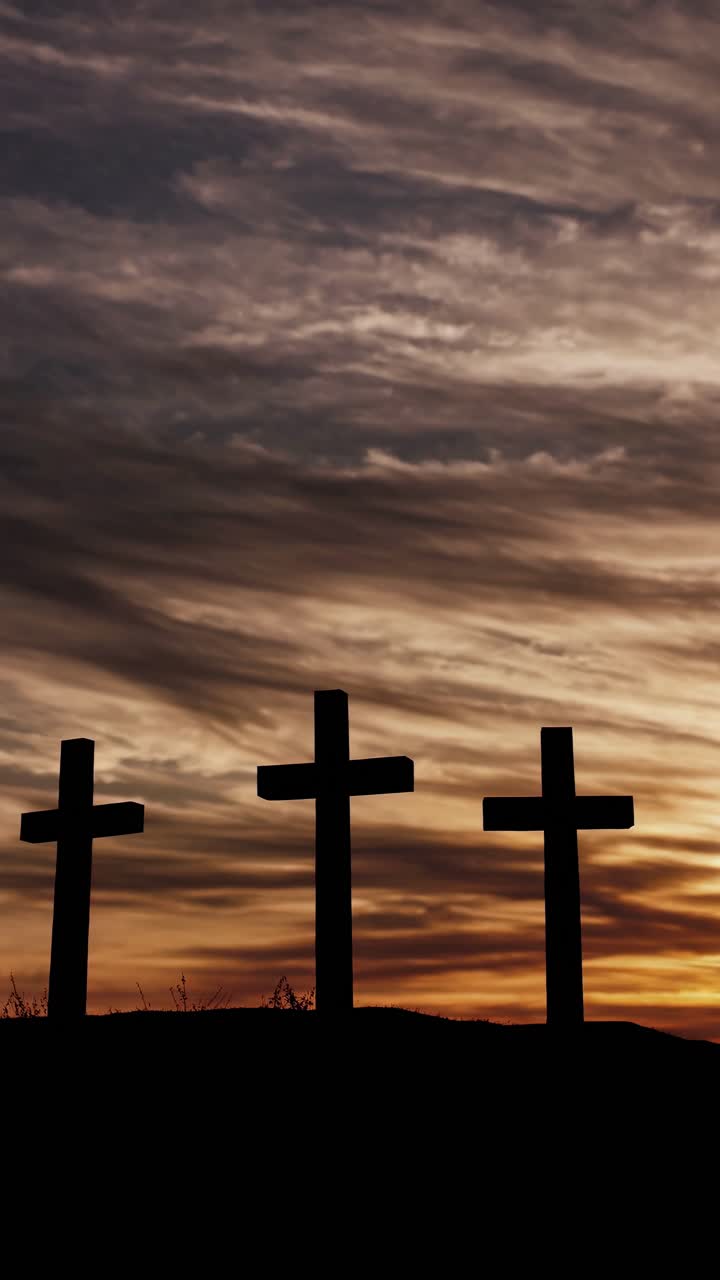 Silhouetted crosses against a dramatic sunset sky, captured from a low angle