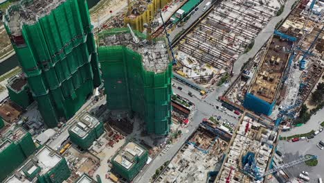 aerial view of constructed building structures covered in safety nets. drone shot