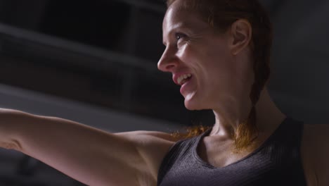 portrait shot of mature smiling woman wearing gym fitness clothing exercising