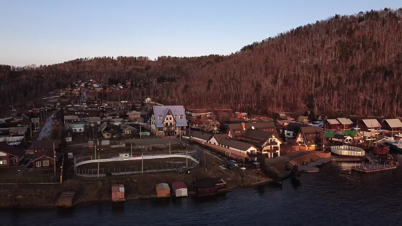 Małe syberyjskie miasteczko z bladymi jesiennymi kolorami nad brzegami Jeziora Bajkał, Rosja, ujęcie panoramiczne.