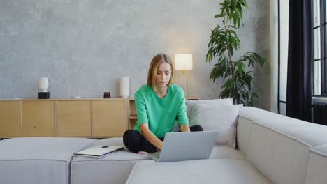 mujer trabajando desde casa en el sofá