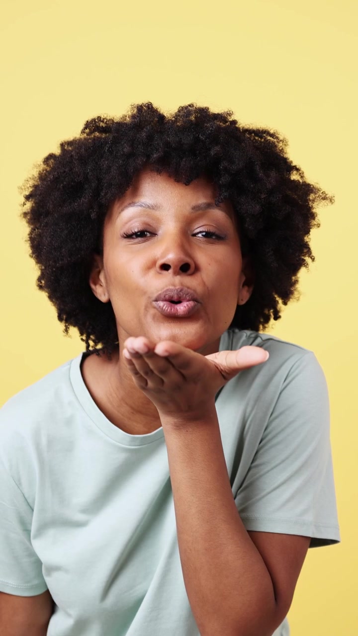 Cheerful African American Woman Smiling, Blowing a Kiss, and Laughing