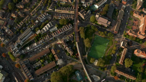 top down aerial shot over london overground train passing through residential neighbourhoods