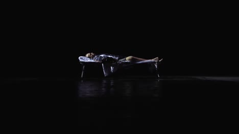 person lying down on a bed in the dark