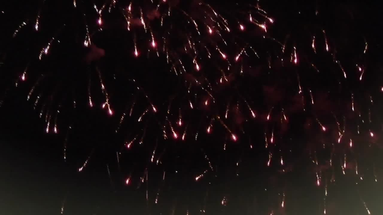 크리스마스 장식과 창문 프레임은 검은 배경에 불꽃놀이가 터지고 있습니다.