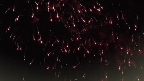 decoraciones de navidad y marco de ventana sobre fuegos artificiales estallando contra un fondo negro